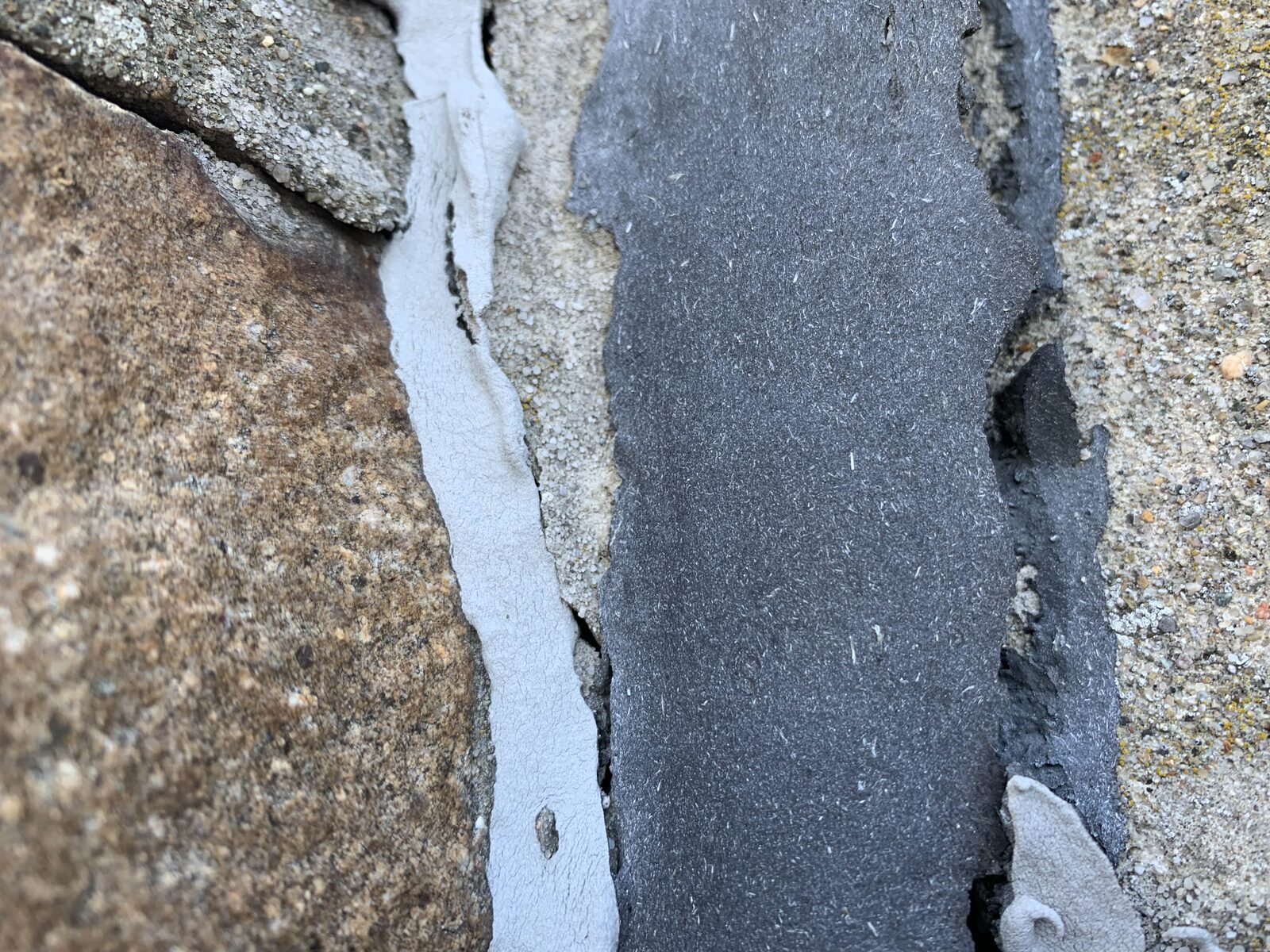 Close view of cracked stone joints and deteriorated patching on the tower