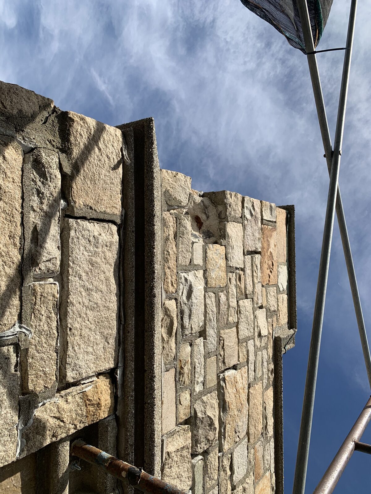 Close view of open joints and weathered stone at the upper parapet