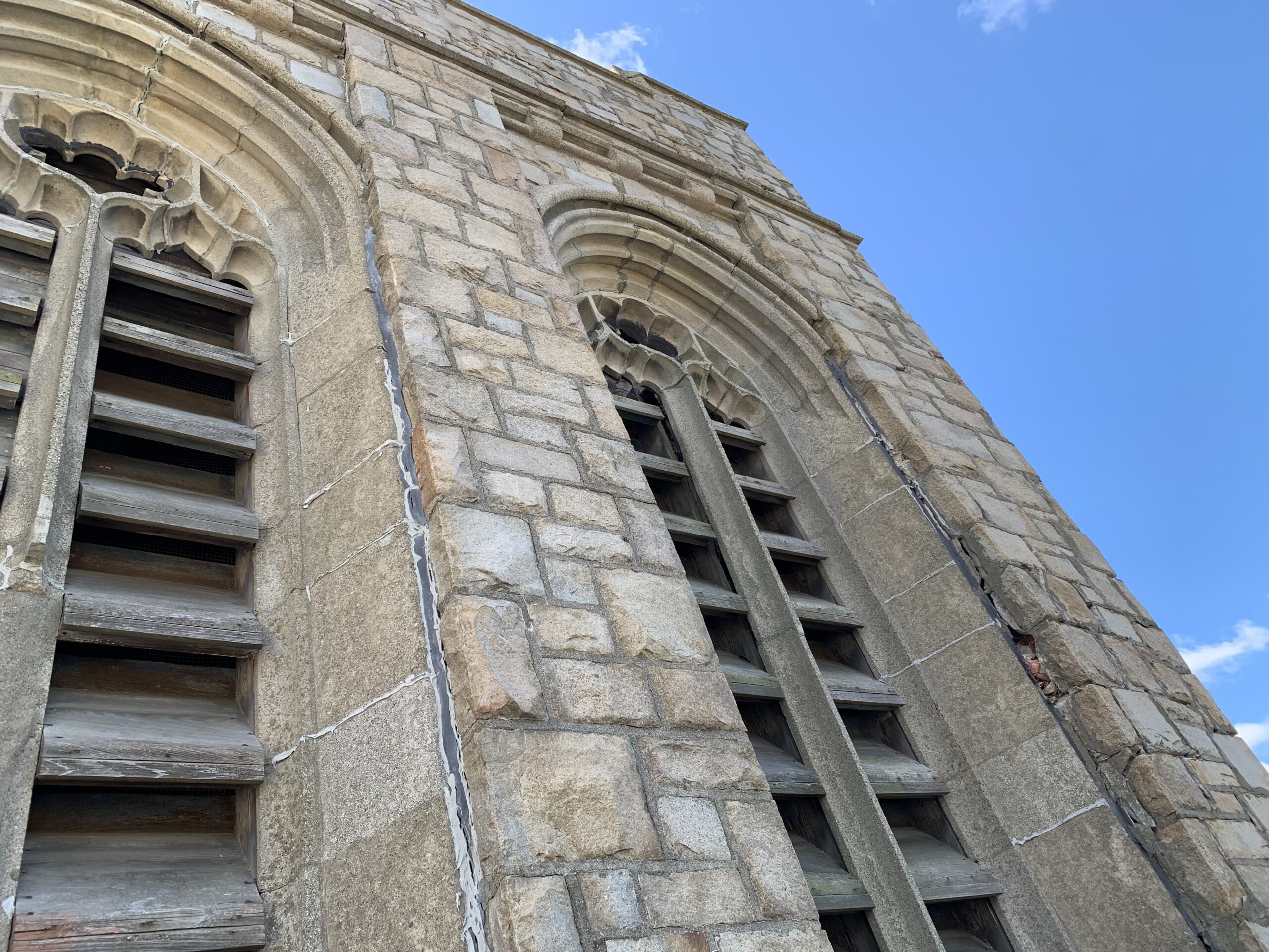 Stone arches and visible cracking on the Christ The Rock Church bell tower